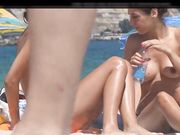Chica joven con hermosas tetas es filmada por voyeur en la playa